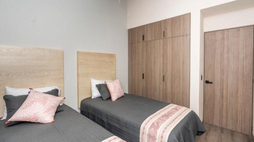 a bedroom with two beds and a wooden cabinet at 4BR Oasis with Pool & Gym at Nueva Escondida in San Miguel de Allende
