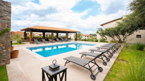 a pool with lounge chairs and a gazebo at 4BR Oasis with Pool & Gym at Nueva Escondida in San Miguel de Allende