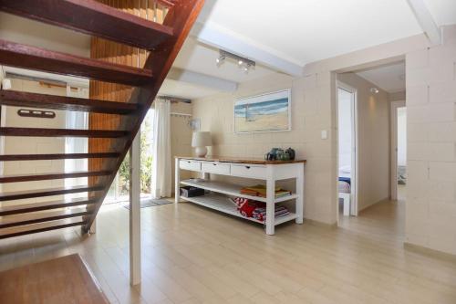 ein Wohnzimmer mit einer Treppe und einem Schreibtisch in der Unterkunft Riverwatch in Hawks Nest