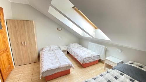 sypialnia z 2 łóżkami i świetlikiem w obiekcie Pokoje Gościnne R10 w Rewie