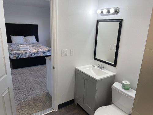 a bathroom with a sink and a toilet and a bed at Banfield Studios in Portland