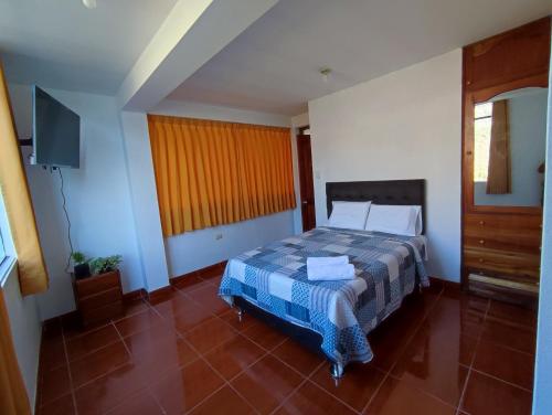 a bedroom with a bed and a television in it at Casa QENTE in Cusco