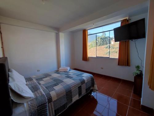 1 dormitorio con cama y ventana en Casa QENTE, en Cusco