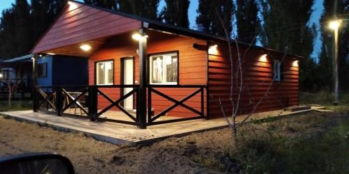 una pequeña cabaña de madera con luces. en Cabaña De Campo en Villa Regina