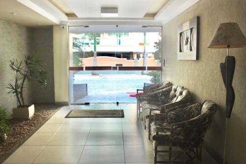 a living room with couches and a large window at Aconchegante 3 quartos na Prainha in Arraial do Cabo