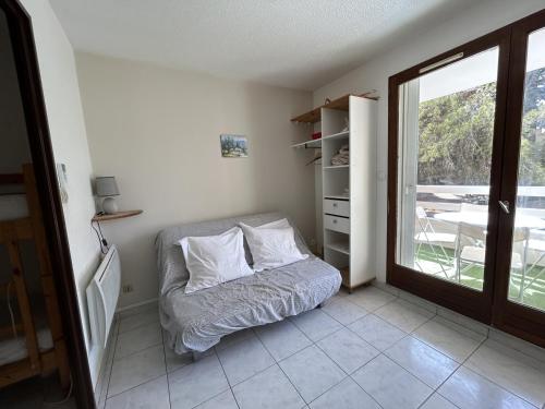 une chambre avec un lit et une porte coulissante en verre dans l'établissement Studio cabine à Sète avec piscine, terrasse, parking privé, à 1km de la plage - FR-1-338-504, à Sète