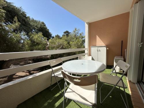 d'une table et de chaises blanches sur un balcon avec fenêtre. dans l'établissement Studio cabine à Sète avec piscine, terrasse, parking privé, à 1km de la plage - FR-1-338-504, à Sète