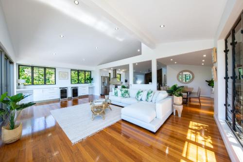 Una sala de estar con un sofá blanco y una mesa. en Seaview On Airlie, en Airlie Beach