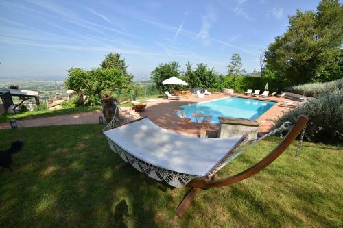 a yard with a swimming pool with a swing at Villa Clara in Assisi