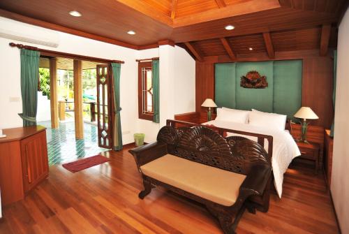 1 dormitorio con 1 cama y un banco en una habitación en Villa Melitta, Pool, Beach, 360-SeaViews, 6-bed Thai Luxury on Best Location in Samui en Bang Rak Beach