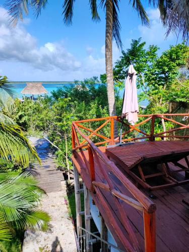 a wooden table with an umbrella and a table with the ocean at Villa Ensueño, Lagoon Private Front in Bacalar