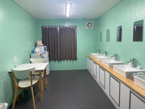 a bathroom with three sinks and a row of toilets at GUESTHOUSE富士と碧 in Fuji