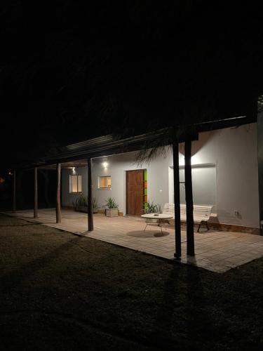 un edificio de noche con un banco y una mesa en Tu alojamiento en Santiago del Estero en Santiago del Estero