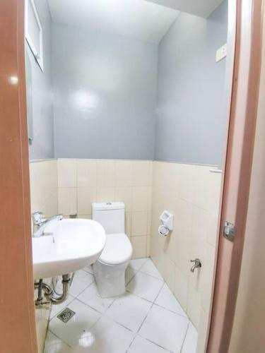 a bathroom with a white toilet and a sink at Private Townhouse (Serenia Homestay) in San Juan