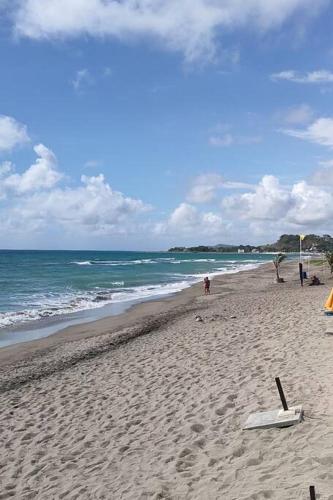 a beach with people and the ocean on a cloudy day at Private Townhouse (Serenia Homestay) in San Juan