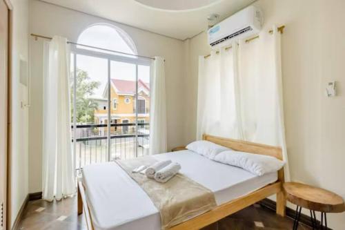 a bedroom with a bed and a large window at Private Townhouse (Serenia Homestay) in San Juan