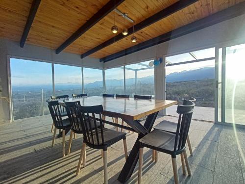 comedor con mesa y sillas en la terraza en Crucecita Eco Lodge en Mendoza