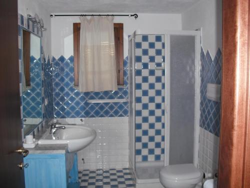 un bagno blu e bianco con lavandino e servizi igienici di Casa Vacanze Il Pino a Cannigione