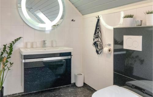 een badkamer met een wastafel, een toilet en een spiegel bij 4 Bedroom Cozy Home In Stord in Stord