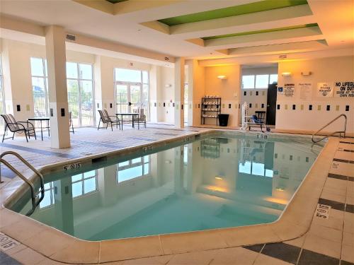 a swimming pool in a building with a table and chairs at Holiday Inn Columbia East, an IHG Hotel in Columbia