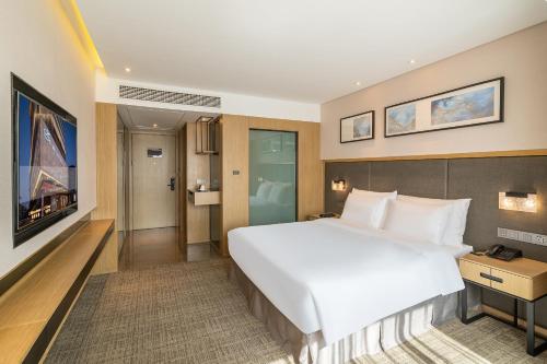 a large white bed in a hotel room at Zenith Hotel-Near Train Station & The Mixc in Xiamen