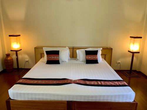 a bedroom with a large bed with two lamps at Asia Grand View Hotel in Coron