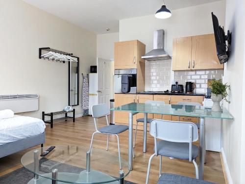 a kitchen with a table and chairs in a room at Lovely Studio In Anfield Near Centre Free Parking in Liverpool