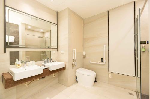 y baño con lavabo, aseo y espejo. en Euphoria Hotel Lukang en Lugang