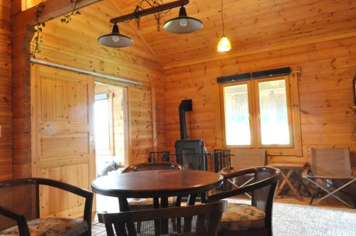 a dining room with a table and chairs in a cabin at Log Cottage be with nature in Furano