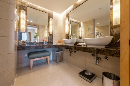 łazienka z 2 umywalkami i niebieskim krzesłem w obiekcie Crowne Plaza Shanghai, an IHG Hotel w Szanghaju