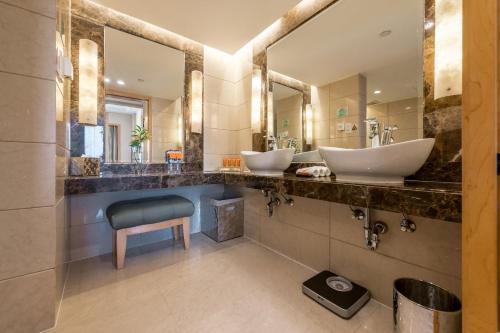 a bathroom with two sinks and a blue chair at Crowne Plaza Shanghai by IHG in Shanghai