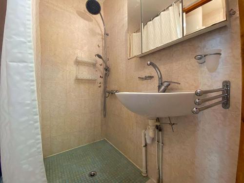 une salle de bain avec un lavabo et une douche dans l'établissement Maison PMR avec Terrasse, Clim et Parking à 900m de la Mer - 4 Couchages - FR-1-229-872, à Gruissan