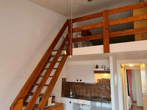 une cuisine avec un escalier menant à un loft dans l'établissement Port-la-Nouvelle: T2 Mezzanine, Terrasse, Parking, à 300m de la Plage! - FR-1-229C-85, à Port-la-Nouvelle