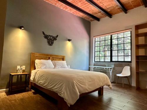 a bedroom with a bed and a desk and a window at Casa Raffaello in Mexico City