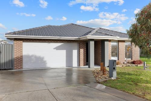 une maison avec une porte de garage blanche dans l'établissement The Grampian in Cowes BYO LINEN & TOWELS, à Cowes
