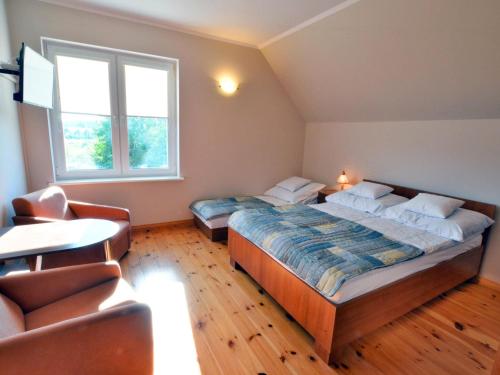 a bedroom with two beds and a table and a couch at Holiday house with private garden, Jaros awiec in Jarosławiec