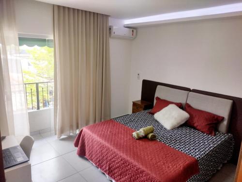 ein Teddybär auf einem Bett in einem Schlafzimmer in der Unterkunft Flat Ideal para conexão 5 in Guarulhos