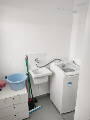 a bathroom with a sink and a washing machine at Flat Ideal para conexão 7 in Guarulhos