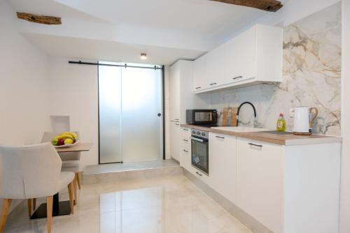a kitchen with white cabinets and a counter top at Solomon Royal Garden in Kritsá