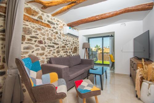 a living room with a stone wall at Solomon Royal Garden in Kritsá