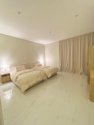 a bedroom with a large bed and a large window at AMA APARTMENT in Ar Rass