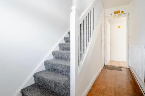 a staircase in a home with white walls at North Avenue Guest House Ltd, Heathrow Airport-Free Parking in Hayes