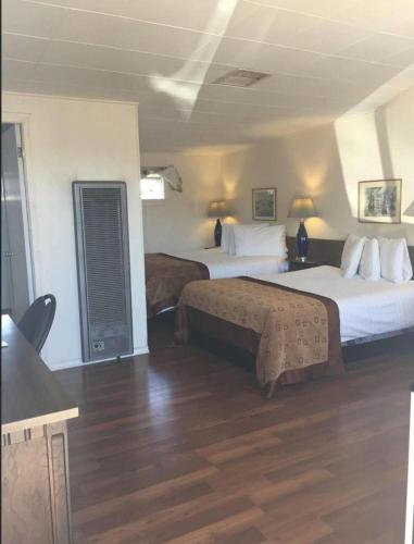 ein Hotelzimmer mit 2 Betten und Holzböden in der Unterkunft Robbie's Motel in Cache Creek