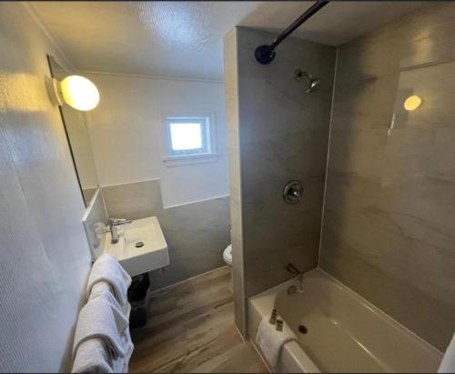 a bathroom with a shower and a sink and a tub at Robbie's Motel in Cache Creek