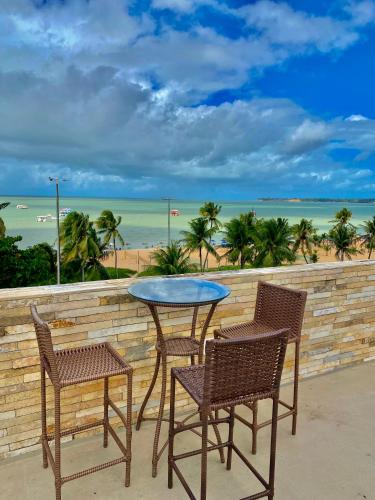 a table and chairs with a view of the beach at Beira Mar Imperial Flat 612 in João Pessoa