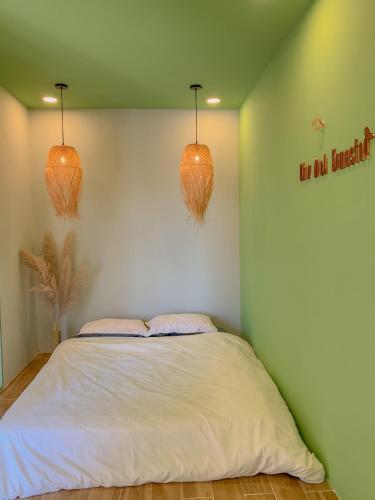 a bedroom with a bed with two lights on the wall at Chon's Dock Homestay & Apartment For Lease in Phan Thiet