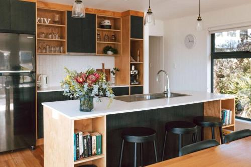 a kitchen with a counter with a vase of flowers at B e a c h H o u s e X I V in Bicheno
