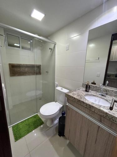a bathroom with a toilet and a shower and a sink at Flat Beira Mar de Intermares in Cabedelo