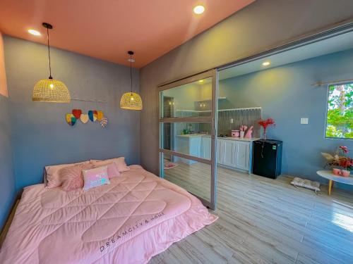 a bedroom with a pink bed and a large window at Chon's Dock Homestay & Apartment For Lease in Phan Thiet