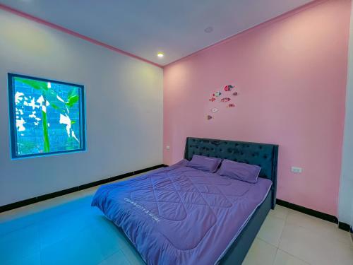 a bedroom with pink and purple walls and a bed at Chon's Dock Homestay & Apartment For Lease in Phan Thiet